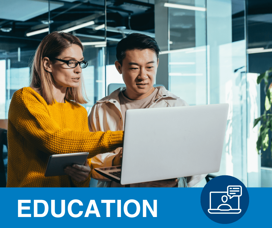 Caucasian women in a yellow sweater looking at a laptop with an asian man in a business office. This is a link to PRIM&R education pages.